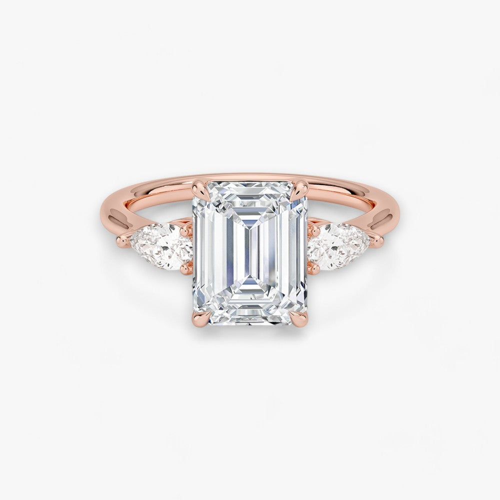 Eleganter Verlobungsring mit 2-Karat Emerald-Cut-Diamant und funkelnden seitlichen Pear-Cut-Diamanten, gefertigt aus hochwertigem Rosegold. Luxuriöser Diamantring für Verlobung, Hochzeit oder Jubiläum. Exklusives Schmuckdesign mit brillantem Glanz und zeitloser Eleganz – ideal für besondere Momente. Perfekter Verlobungsring mit außergewöhnlicher Handwerkskunst. Jetzt online entdecken und bestellen.