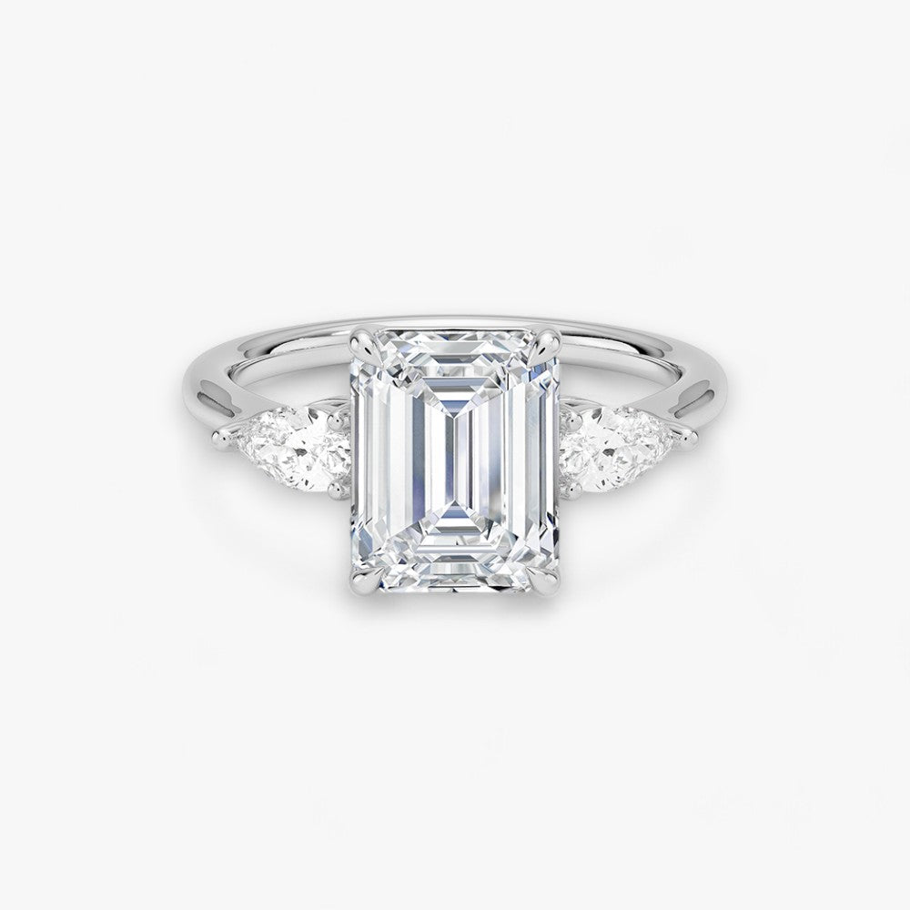 Eleganter Verlobungsring mit 2-Karat Emerald-Cut-Diamant und funkelnden seitlichen Pear-Cut-Diamanten, gefertigt aus hochwertigem Weissgold. Luxuriöser Diamantring für Verlobung, Hochzeit oder Jubiläum. Exklusives Schmuckdesign mit brillantem Glanz und zeitloser Eleganz – ideal für besondere Momente. Perfekter Verlobungsring mit außergewöhnlicher Handwerkskunst. Jetzt online entdecken und bestellen.