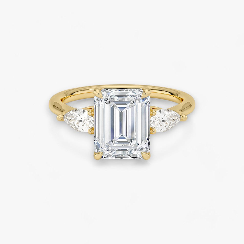 Eleganter Verlobungsring mit 2-Karat Emerald-Cut-Diamant und funkelnden seitlichen Pear-Cut-Diamanten, gefertigt aus hochwertigem Gelbgold. Luxuriöser Diamantring für Verlobung, Hochzeit oder Jubiläum. Exklusives Schmuckdesign mit brillantem Glanz und zeitloser Eleganz – ideal für besondere Momente. Perfekter Verlobungsring mit außergewöhnlicher Handwerkskunst. Jetzt online entdecken und bestellen.