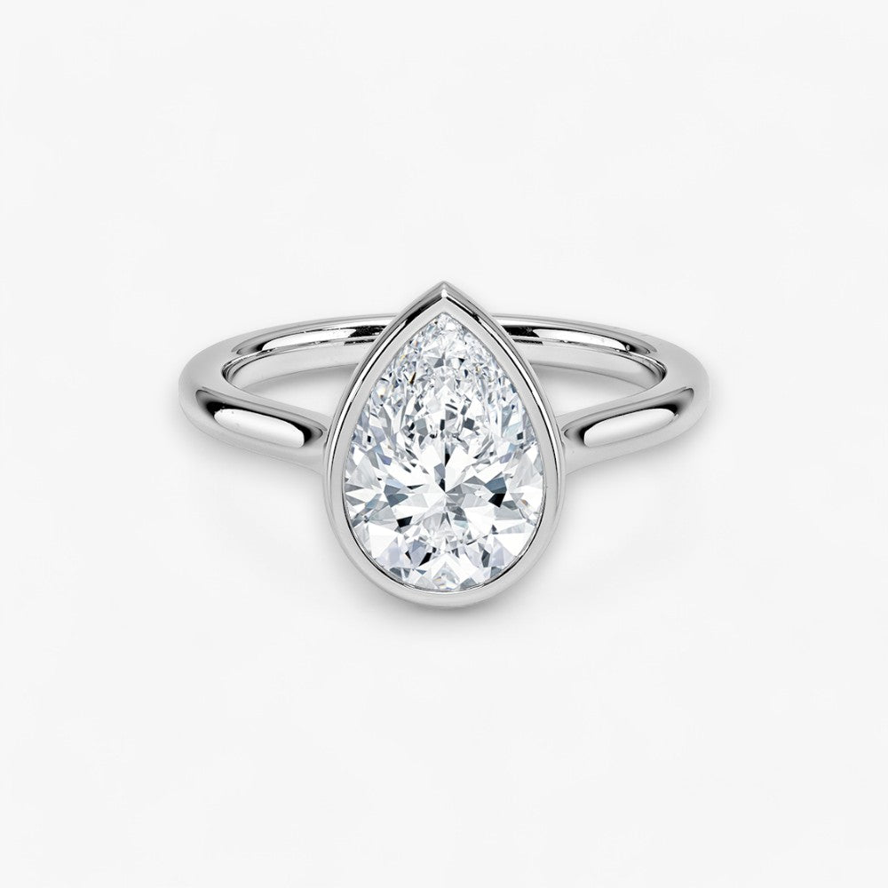 Moderner Verlobungsring mit 2-Karat Tropfen-Cut-Diamant in einer stilvollen Zargenfassung aus hochwertigem Weissgold. Minimalistisches Schmuckdesign mit luxuriösem Glanz und zeitloser Eleganz, ideal für Verlobung, Hochzeit oder Jubiläum. Exklusiver Diamantring, der Handwerkskunst und modernes Design vereint. Jetzt den perfekten Verlobungsring für besondere Momente online entdecken und kaufen.