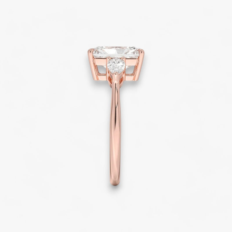 Eleganter Verlobungsring mit 2-Karat Radiant-Cut-Diamant und funkelnden seitlichen Pear-Cut-Diamanten, gefertigt aus hochwertigem Rosegold. Luxuriöser Diamantring für Verlobung, Hochzeit oder Jubiläum. Exklusives Schmuckdesign mit brillantem Glanz und zeitloser Eleganz – ideal für besondere Momente. Perfekter Verlobungsring mit außergewöhnlicher Handwerkskunst. Jetzt online entdecken und bestellen.