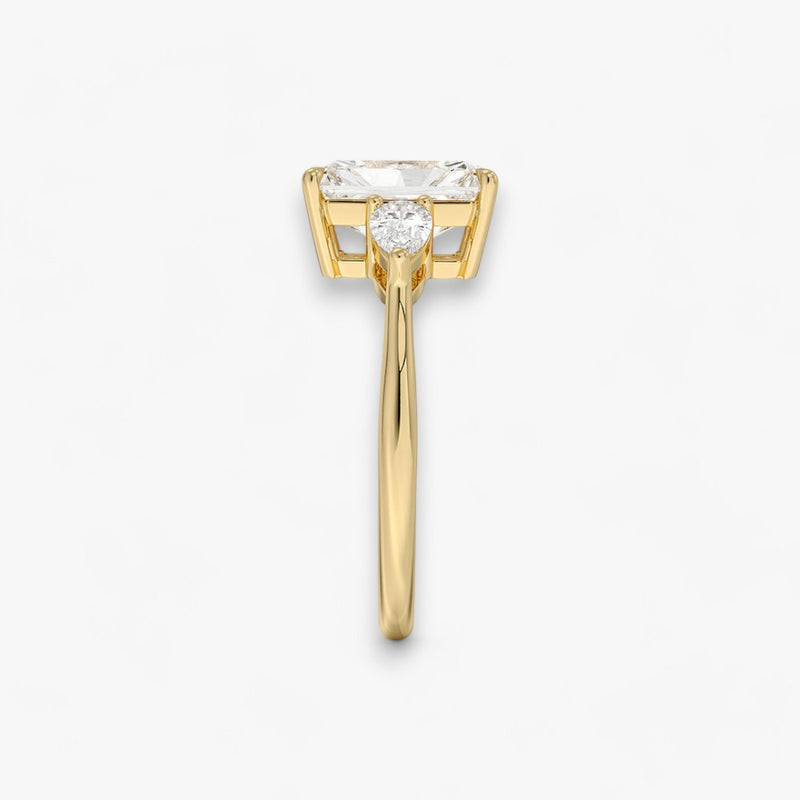 Eleganter Verlobungsring mit 2-Karat Radiant-Cut-Diamant und funkelnden seitlichen Pear-Cut-Diamanten, gefertigt aus hochwertigem Gelbgold. Luxuriöser Diamantring für Verlobung, Hochzeit oder Jubiläum. Exklusives Schmuckdesign mit brillantem Glanz und zeitloser Eleganz – ideal für besondere Momente. Perfekter Verlobungsring mit außergewöhnlicher Handwerkskunst. Jetzt online entdecken und bestellen.