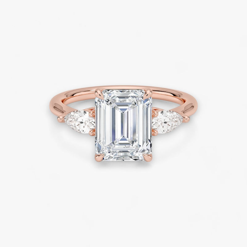 Eleganter Verlobungsring mit 2-Karat Emerald-Cut-Diamant und funkelnden seitlichen Pear-Cut-Diamanten, gefertigt aus hochwertigem Rosegold. Luxuriöser Diamantring für Verlobung, Hochzeit oder Jubiläum. Exklusives Schmuckdesign mit brillantem Glanz und zeitloser Eleganz – ideal für besondere Momente. Perfekter Verlobungsring mit außergewöhnlicher Handwerkskunst. Jetzt online entdecken und bestellen.