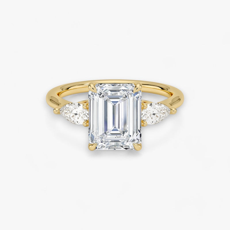 Eleganter Verlobungsring mit 2-Karat Emerald-Cut-Diamant und funkelnden seitlichen Pear-Cut-Diamanten, gefertigt aus hochwertigem Gelbgold. Luxuriöser Diamantring für Verlobung, Hochzeit oder Jubiläum. Exklusives Schmuckdesign mit brillantem Glanz und zeitloser Eleganz – ideal für besondere Momente. Perfekter Verlobungsring mit außergewöhnlicher Handwerkskunst. Jetzt online entdecken und bestellen.