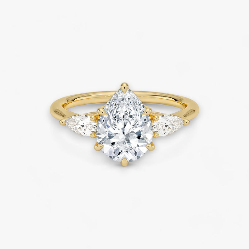 Eleganter Verlobungsring mit 2-Karat Tropfen-Cut-Diamant und funkelnden seitlichen Pear-Cut-Diamanten, gefertigt aus hochwertigem Gelbgold. Luxuriöser Diamantring für Verlobung, Hochzeit oder Jubiläum. Exklusives Schmuckdesign mit brillantem Glanz und zeitloser Eleganz – ideal für besondere Momente. Perfekter Verlobungsring mit außergewöhnlicher Handwerkskunst. Jetzt online entdecken und bestellen.