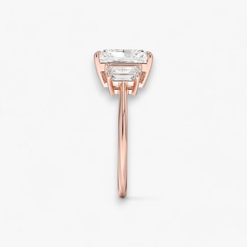 Luxuriöser Verlobungsring mit 2-Karat Radiant-Cut-Diamant und seitlichen Emerald-Cut-Diamanten, eingefasst in einer eleganten Rosegold-Fassung. Exklusiver Diamantring mit brillantem Glanz und moderner Ästhetik, ideal für Verlobung, Hochzeit oder Jubiläum. Hochwertiges Schmuckdesign mit zeitloser Eleganz und handgefertigter Präzision. Perfekter Verlobungsring für besondere Momente. Jetzt online entdecken und bestellen.