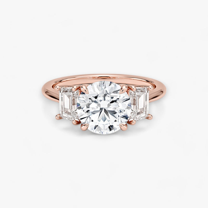 Luxuriöser Verlobungsring mit 2-Karat Rund-Cut-Diamant und seitlichen Emerald-Cut-Diamanten, eingefasst in einer eleganten Rosegold-Fassung. Exklusiver Diamantring mit brillantem Glanz und moderner Ästhetik, ideal für Verlobung, Hochzeit oder Jubiläum. Hochwertiges Schmuckdesign mit zeitloser Eleganz und handgefertigter Präzision. Perfekter Verlobungsring für besondere Momente. Jetzt online entdecken und bestellen.