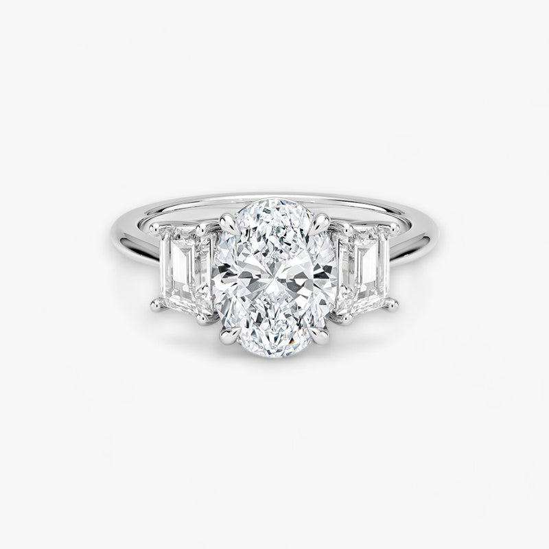 Luxuriöser Verlobungsring mit 2-Karat Oval-Cut-Diamant und seitlichen Emerald-Cut-Diamanten, eingefasst in einer eleganten Weissgold-Fassung. Exklusiver Diamantring mit brillantem Glanz und moderner Ästhetik, ideal für Verlobung, Hochzeit oder Jubiläum. Hochwertiges Schmuckdesign mit zeitloser Eleganz und handgefertigter Präzision. Perfekter Verlobungsring für besondere Momente. Jetzt online entdecken und bestellen.
