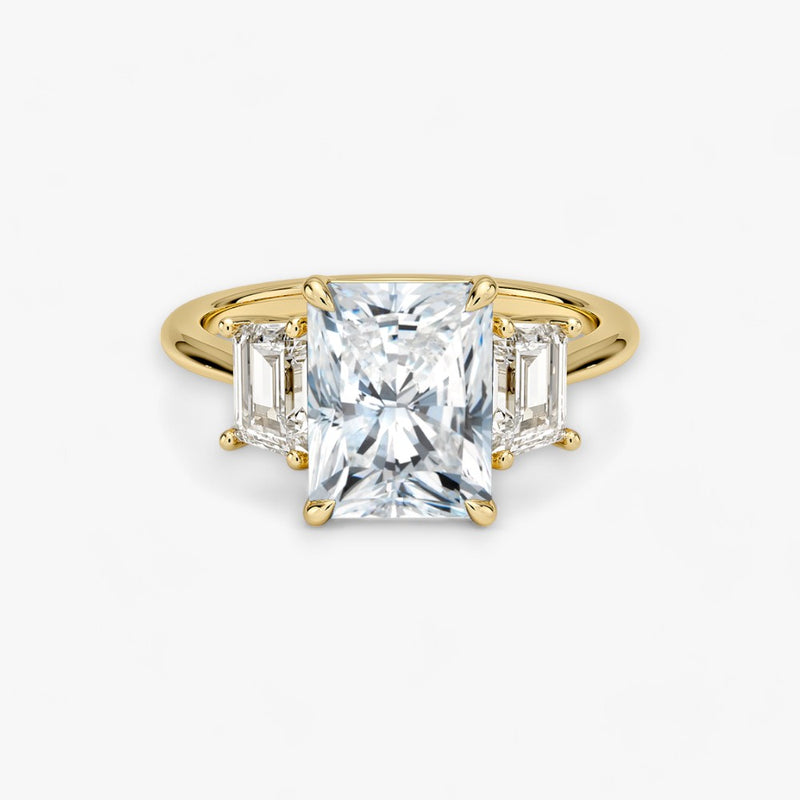 Luxuriöser Verlobungsring mit 2-Karat Radiant-Cut-Diamant und seitlichen Emerald-Cut-Diamanten, eingefasst in einer eleganten Gelbgold-Fassung. Exklusiver Diamantring mit brillantem Glanz und moderner Ästhetik, ideal für Verlobung, Hochzeit oder Jubiläum. Hochwertiges Schmuckdesign mit zeitloser Eleganz und handgefertigter Präzision. Perfekter Verlobungsring für besondere Momente. Jetzt online entdecken und bestellen.