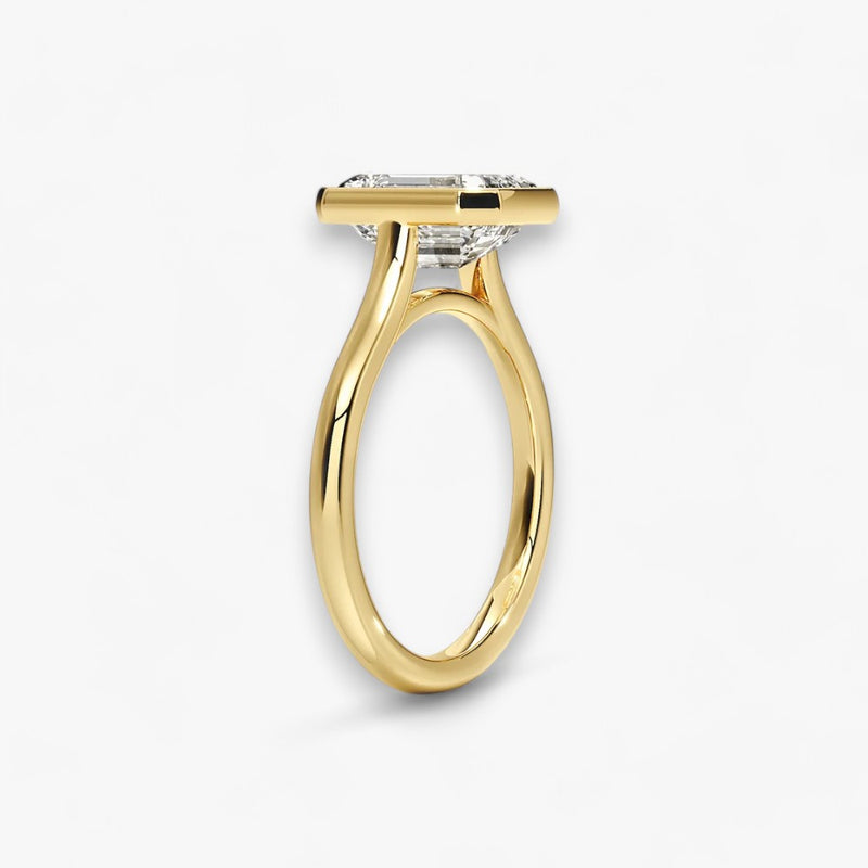 Moderner Verlobungsring mit 2-Karat Emerald-Cut-Diamant in einer stilvollen Zargenfassung aus hochwertigem Gelbgold. Minimalistisches Schmuckdesign mit luxuriösem Glanz und zeitloser Eleganz, ideal für Verlobung, Hochzeit oder Jubiläum. Exklusiver Diamantring, der Handwerkskunst und modernes Design vereint. Jetzt den perfekten Verlobungsring für besondere Momente online entdecken und kaufen.