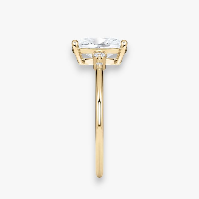 Detailaufnahme des CASCADE Diamantrings in Gelbgold – ovaler Mittelstein mit abgestufter Seitenstein-Fassung, Antragsring von NÓIR Diamonds